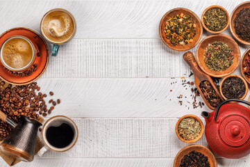 A tantalizing display of roasted coffee beans and dry tea leaves, accompanied by an espresso coffee cup and a teapot