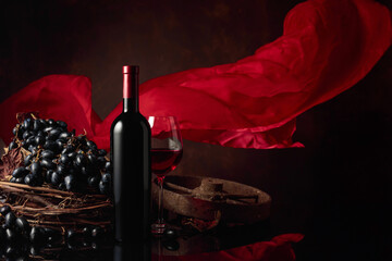 Red wine with grapes on a background of red flutters curtain.