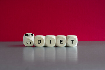 Turned a wooden cube and changes the expression No diet to keto diet. Beautiful grey table, pink background.