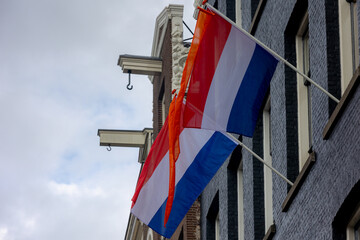 Netherlands flag with horizontal tricolour of red, white and blue, Orange flag hanging outside...
