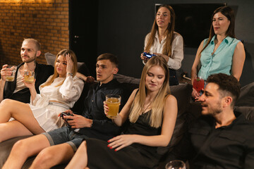 Friends revel in thrill of triumph winning in video games. Fusion of gaming and beverage creates...