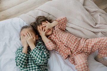 Morning awakening little girls in a bed. Kids wakes up in the bedroom. Morning kids, top view....