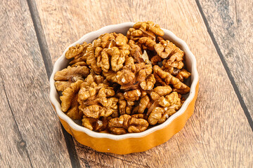 Cracked unshelled walnut in the bowl