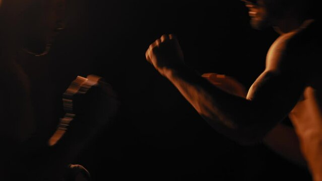 Two fighters fighting each other in a dark room