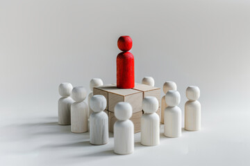 Red wooden figure standing above a group on a platform