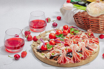 Picnic food concept. Basket with wine and baguette, set of snacks on skewers. Meat, cheese