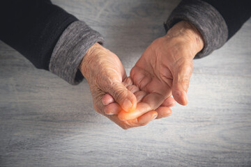 Caucasian elderly woman suffering from finger pain.
