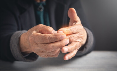 Caucasian elderly woman suffering from finger pain.