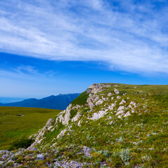 green mountain valley under a blue cloudy sky