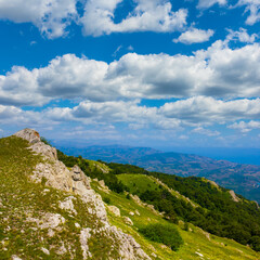 green mountain valley under a blue cloudy sky