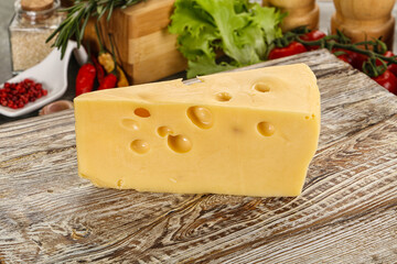 Swiss Maasdam cheese triangle over board