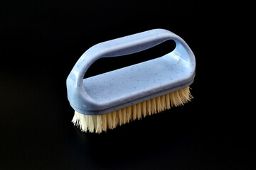 Plastic brush for clothes on a black background.