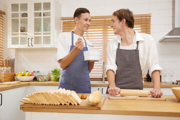 LGBT gay couple making a bread together in the kitchen