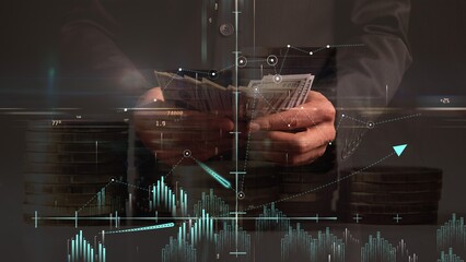 Profitability graphs and coordinate system against the backdrop of hands counting dollar bills and a translucent background of columns of coins. Cg