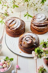 Two-layer vanilla chocolate Easter yeast cake craffin on a ceramic board on a light wooden background. Easter baking, treats, concept.