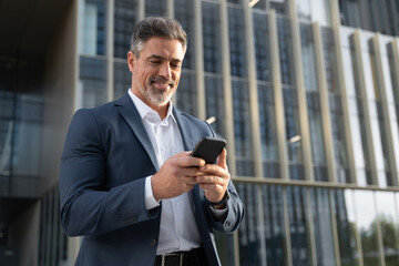 Successful mature hispanic senior business man using smartphone cellphone financial application....
