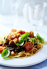 Spaghetti Pasta with Vegetables and fresh Basil on bright wooden Background.