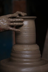 The potter works on a pottery wheel to made of soft colored clay, retro style toned Clay pots with hand and equipment