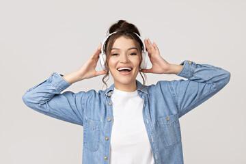 Attractive young girl listens to music in headphones