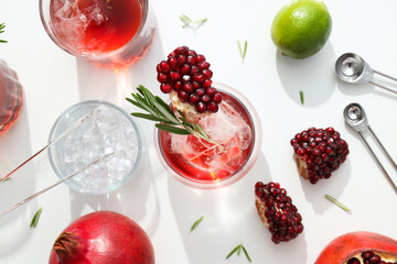 Red cocktail with fresh pomegranate and lime on a white background