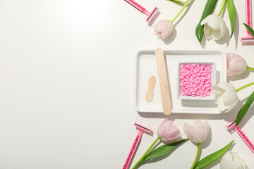 A white tray with depilatory granules and fresh tulips