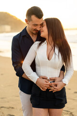 Romantic couple embracing from the back on the beach