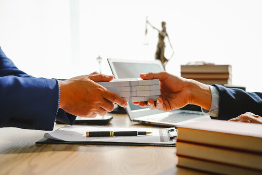 Legal expert navigating corruption cases, including bribery and graft. Businessman consults at desk. Discussions involve bribery, corruption, buying off, and corrupt practices.