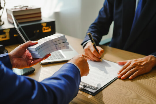 Legal expert navigating corruption cases, including bribery and graft. Businessman consults at desk. Discussions involve bribery, corruption, buying off, and corrupt practices.