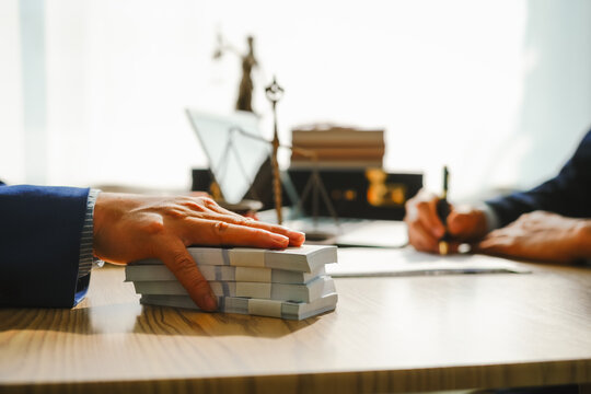 Legal expert navigating corruption cases, including bribery and graft. Businessman consults at desk. Discussions involve bribery, corruption, buying off, and corrupt practices.