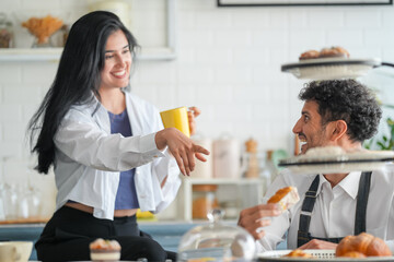 Cheerful loving couple enjoying morning coffee at home, happy spouses having conversation, standing in house