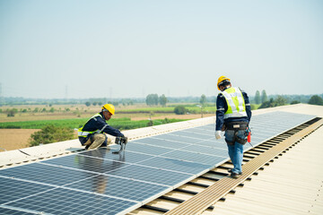 Men technicians carrying photovoltaic solar moduls on roof of house. Builders in helmets installing solar panel system outdoors. Concept of alternative and renewable energy.