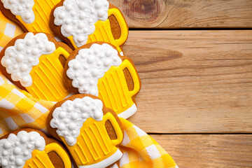 Delicious gingerbread cookies shaped like beer mugs, decorated with icing, displayed on a wooden...