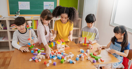 Portrait of asian caucasian little children playing blocks in classroom. Learning by playing...