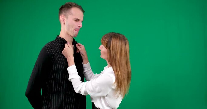 A guy and a girl in black and white clothes, Yin-Yang, talking and smiling on a green background. We look at each other