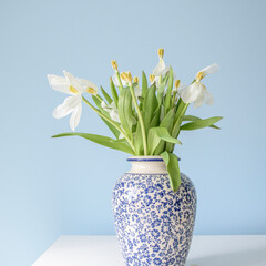 A blue and white vase with white flowers in it