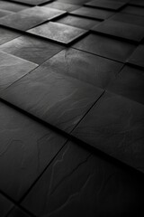 Overhead view of textured black tiles in a geometric arrangement.