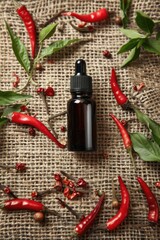 chili pepper essential oil on burlap background