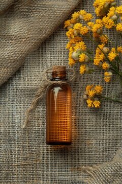 immortelle essential oil on burlap background