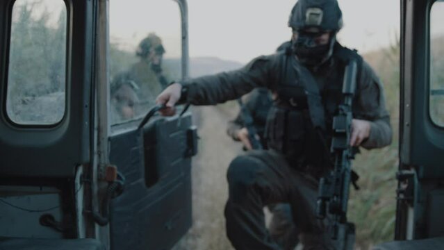 Special forces getting into a moving vehicle near fields outdoors