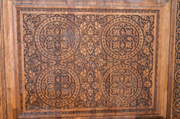 traditional oriental Tajik patterns arabesque ornament in kandakori bagdadi style on an ancient wooden carved door in Tadjikistan