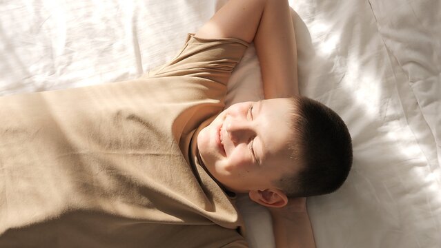 Beaming with happiness childs smile shines under the suns warm embrace. A radiant child gleeful in sunshine's gentle touch The sun's rays dance on child's delighted face, painting picture of pure joy