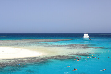 Enchanting view of Egypt's Red Sea coral reef near Marsa Alam, Hamata Islands. Crystal-clear turquoise waters under a warm, sunny sky, perfect for snorkeling.