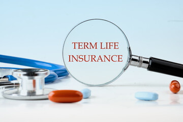 Medical concept. TERM LIFE INSURANCE on a blue background through a magnifying glass