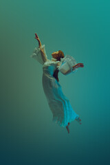 Young woman in white vintage dress exudes sense of deep peace and tranquility, reaching to sky from underwater. Concept of serenity and calm, freedom and levitate, dream, surreality, fantasy. Ad