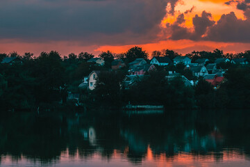 Obraz premium Sunset over the village near the lake