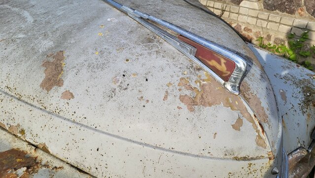 Nice old rusty soviet car Volga on green grass near the building at sunny evening, april 2024 Ukraine