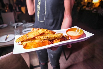 Person Holding Plate of Food in Restaurant