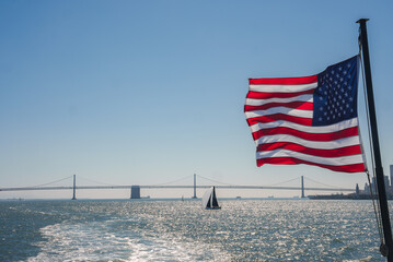 American flag waving in the wind with the Golden Gate Bridge in the background, overlooking San...