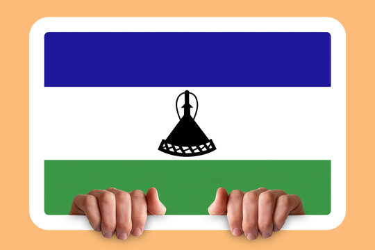 Hands holding a white frame with Lesotho flag, two hands and frame, independence day idea