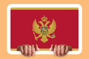 Hands holding a white frame with Montenegro flag, celebration or campaigning concept, two hands 